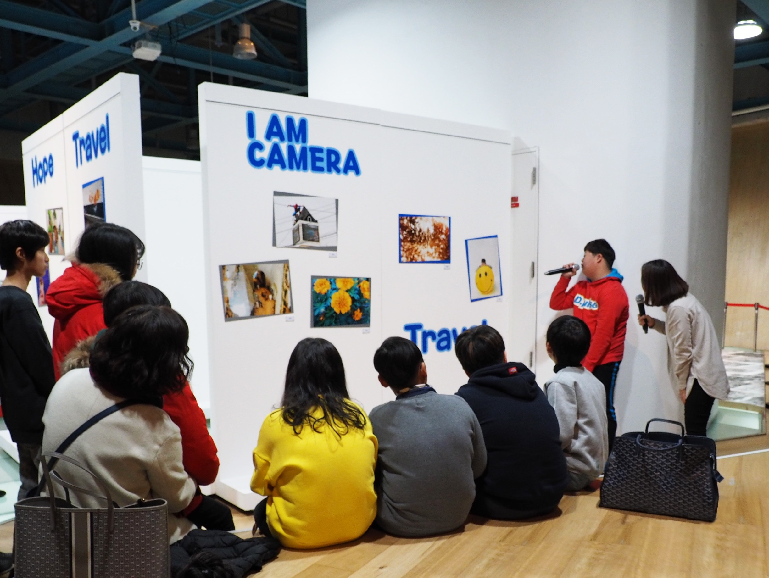‘2018 아이엠 카메라 희망여행 전시회’에서 ‘아이엠 카메라’수강생이 자신의 작품을 소개하고 있다.